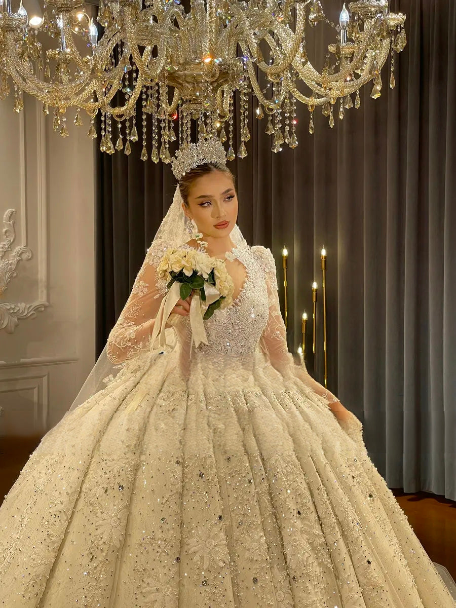 Close-up view of a bride holding a bouquet in an elegant ball gown bridal couture, highlighting the luxury Dubai style hand-beaded lace bodice and a traditional bridal tiara.