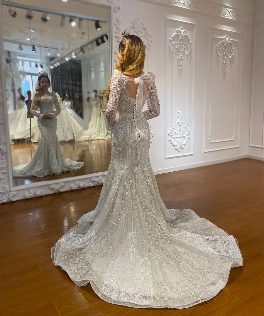 Back view of the form-fitting, form-flattering full lace mermaid wedding dress on a model, highlighting the elegant open-V back design and a long lace train.