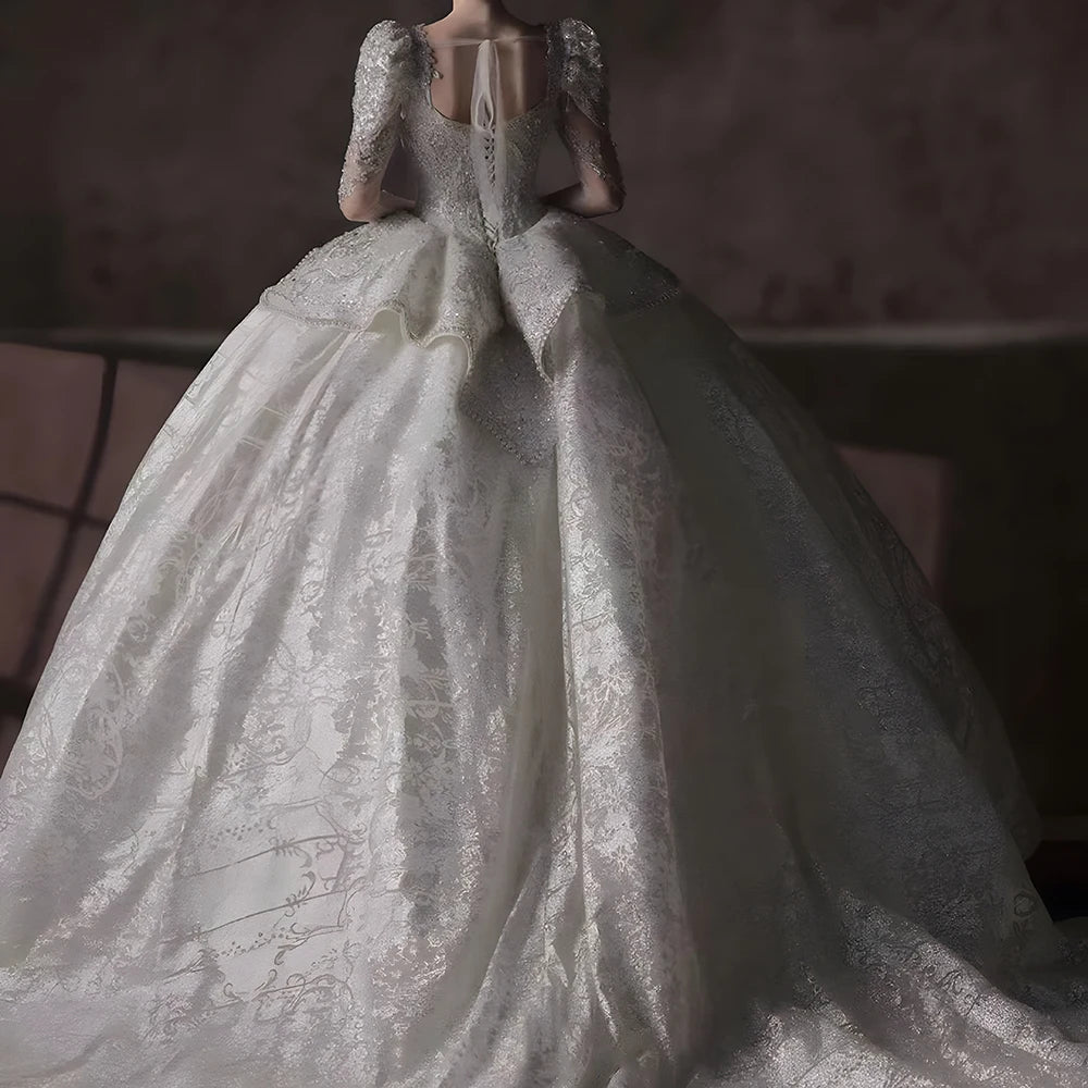 Rear view of a backless shimmering bridal gown showcasing a majestic cathedral-length train and elegant lace-up corset detailing.