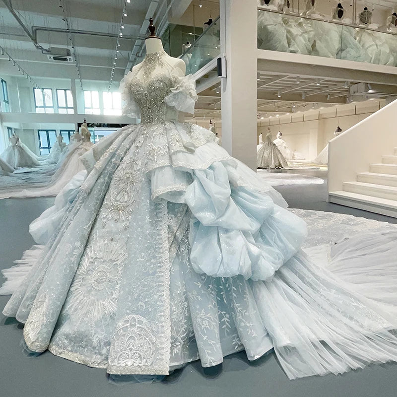 Side profile view of a structured halter princess ball gown on a mannequin, emphasizing the immense volume of the layered organza skirt and trailing train.