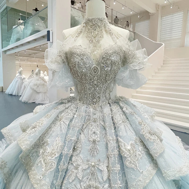 Close-up front detail of a bridal gown bodice, highlighting the elegant halter neck design, high-density crystal beadwork, and custom floral embroidery patterns.