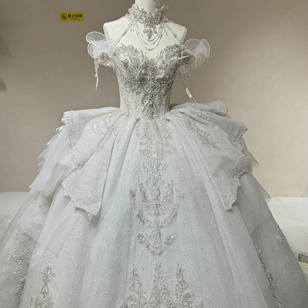 Close-up view of the wedding dress skirt layers, highlighting the clean tailoring of the organza tiers and custom embroidered filigree along the hemline.