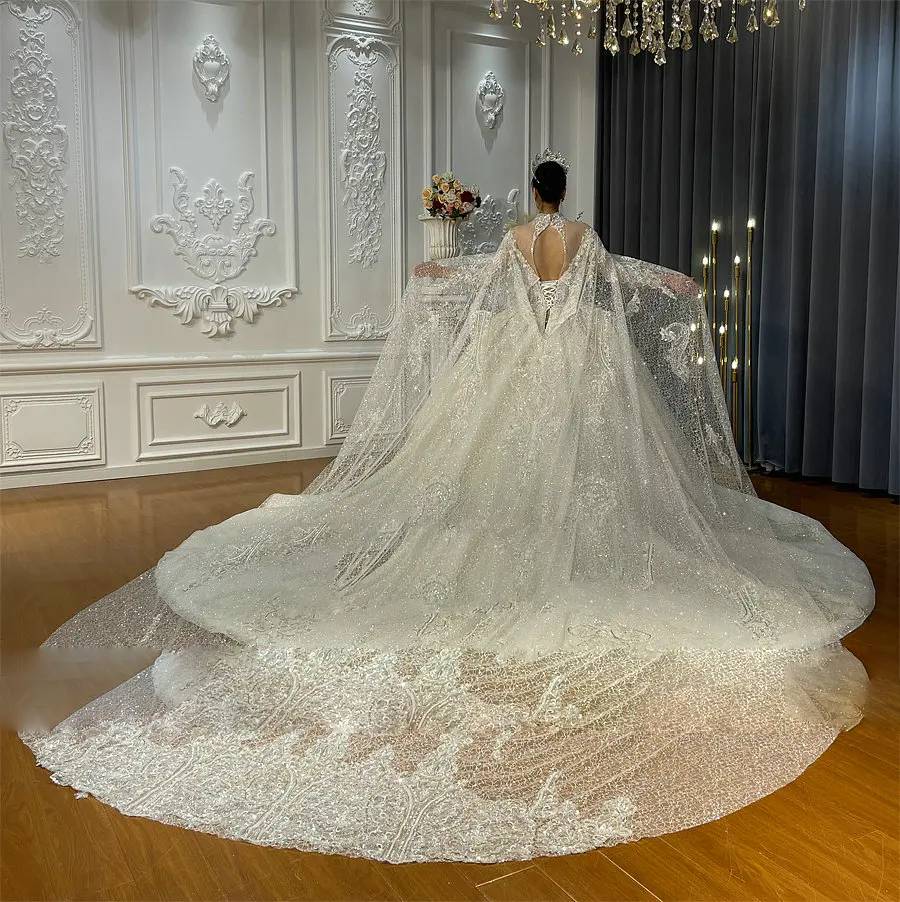 Rear view of a luxury lace wedding dress on a mannequin, emphasizing the regal look of the long cape as it flows into a majestic cathedral-length train.