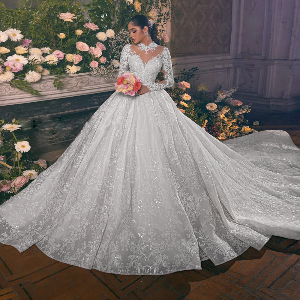 Romantic soft blush pink bridal ball gown with a contrasting white lace O-neck overlay top and a voluminous layered pastel pink tulle skirt.