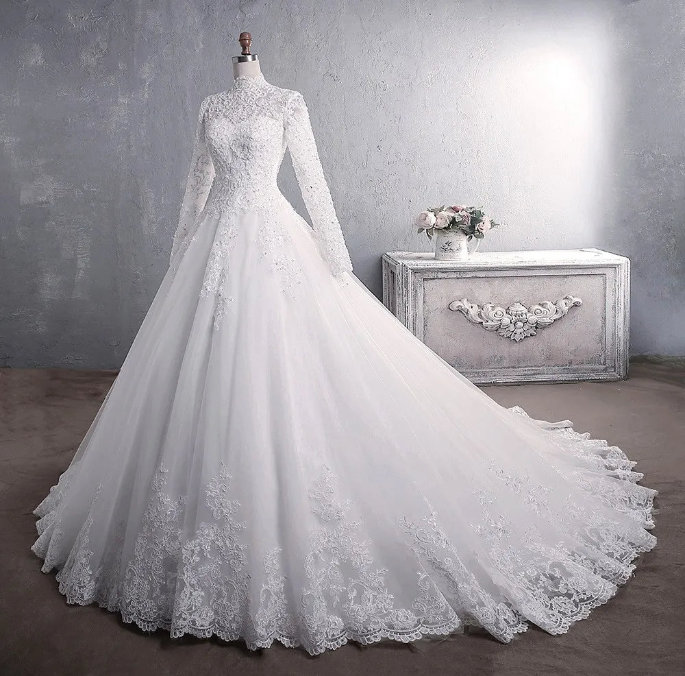 Close-up front portrait focusing on the sophisticated high-neck lace collar, sheer long sleeves with floral lace cuffs, and sparkling crystal beadwork across the structured bodice.
