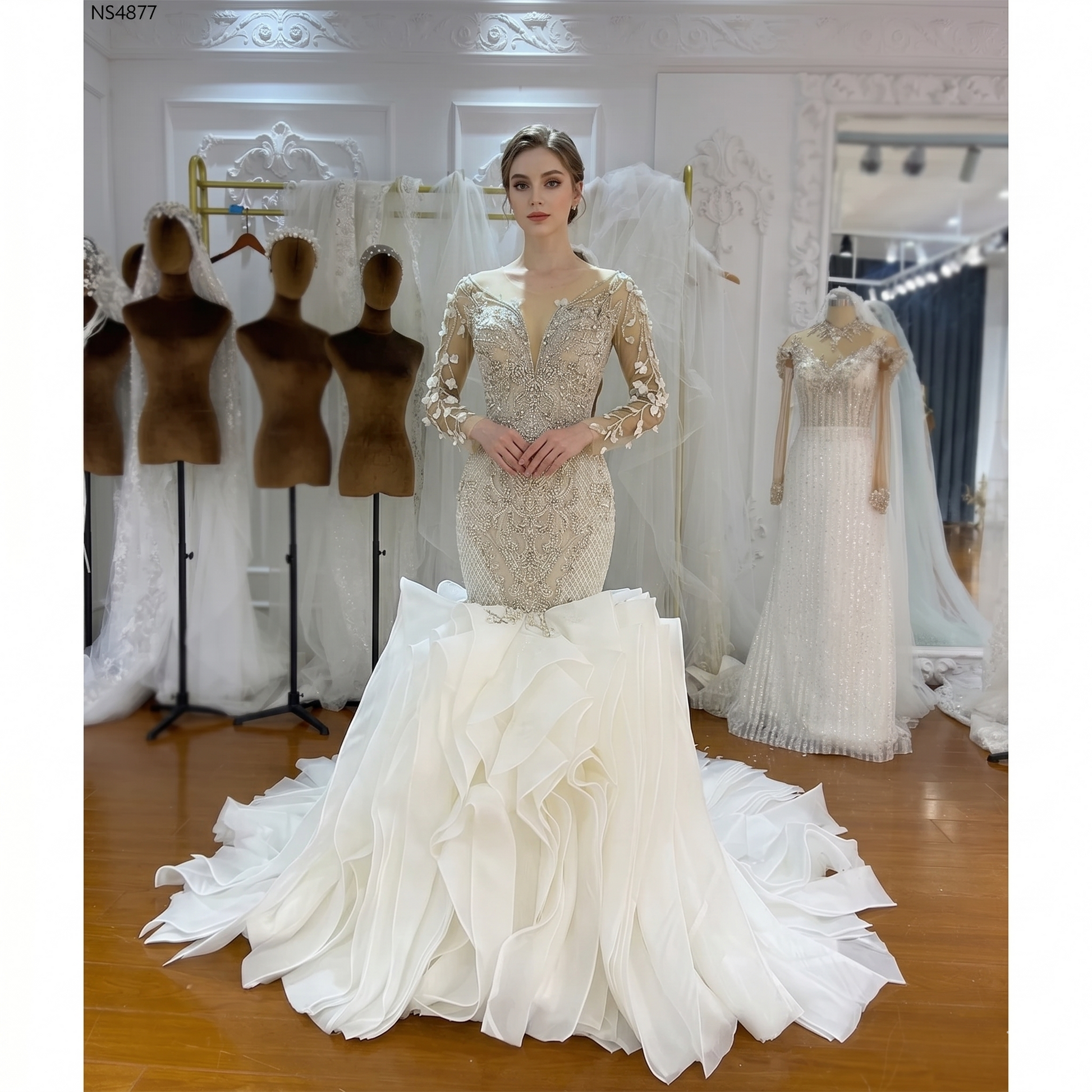 Front view of a model wearing a luxury long-sleeved mermaid wedding dress with an intricately beaded bodice and a dramatic white ruffled organza skirt.