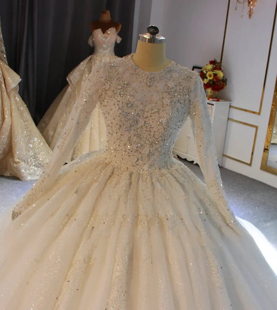 Detailed close-up of the bodice of a luxury modest bridal gown, showcasing premium full beading and hand-stitched crystal embellishments on the neckline and sleeves.