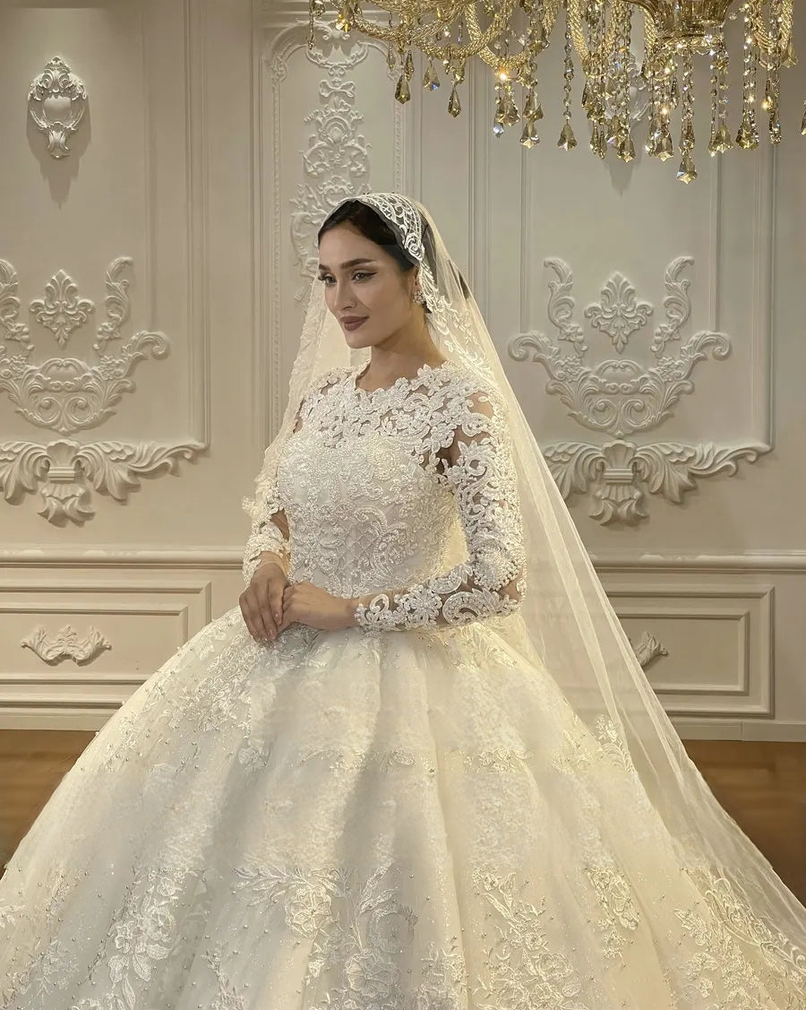 Detailed close-up of the hand-beaded lace bodice and illusion long sleeves on an off-white Muslim wedding gown, emphasizing the high-quality craftsmanship and floral lace patterns.