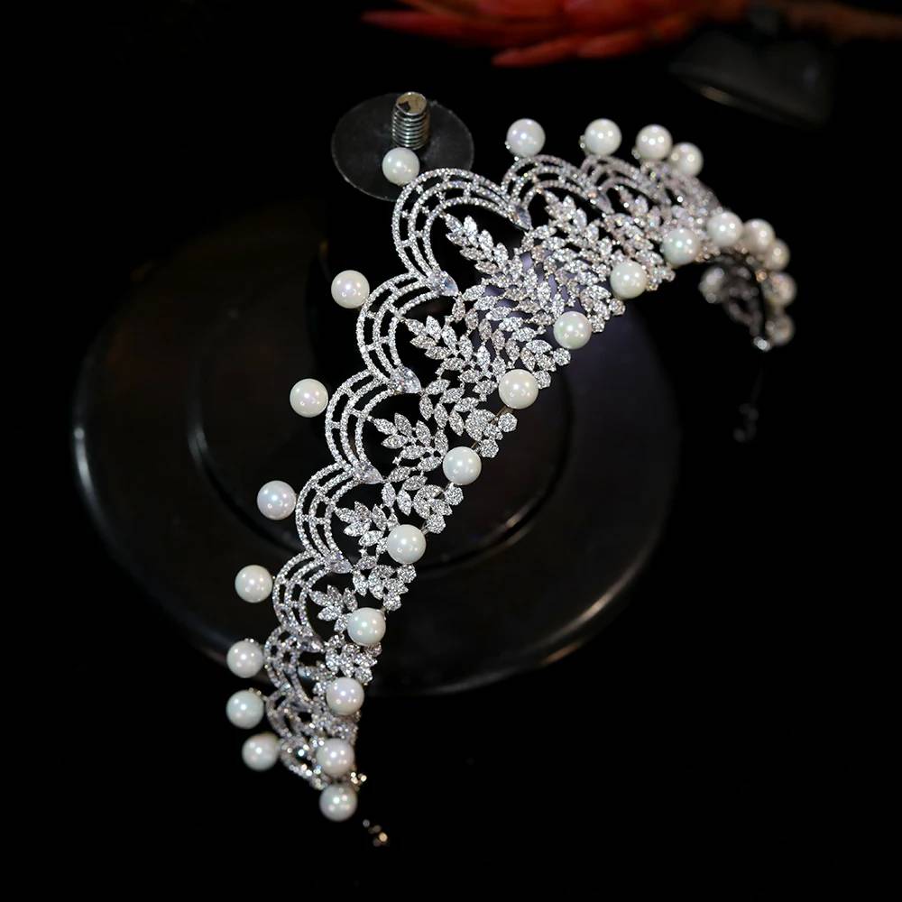 High-angle side perspective of a silver-plated CZ bridal crown tiara highlighting the meticulous placement of round white pearls.