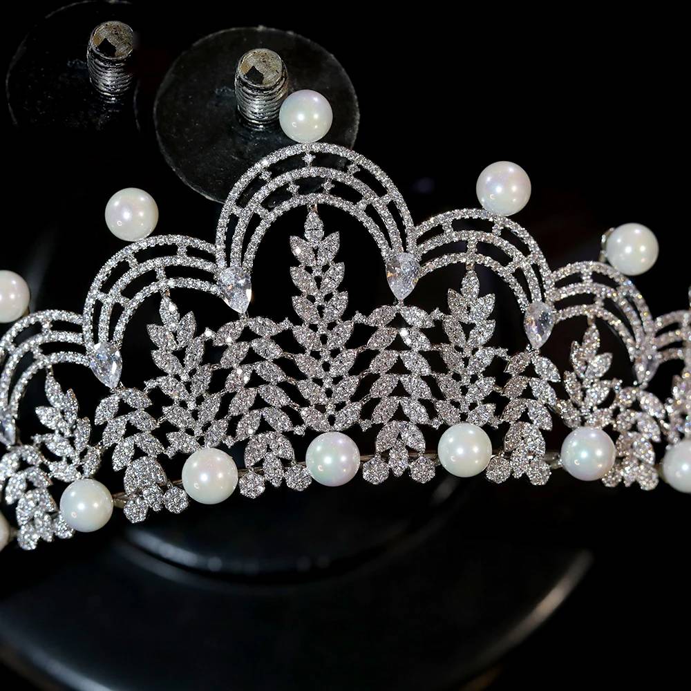 Macro close-up view focusing on the detailed cubic zirconia leaf patterns and symmetrical pearl trimming of a wedding hair accessory.