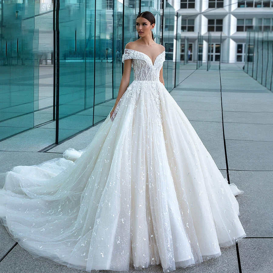 Stunning A-line bridal gown with a strapless bodice, beaded lace details, and a layered, shimmering tulle skirt.
