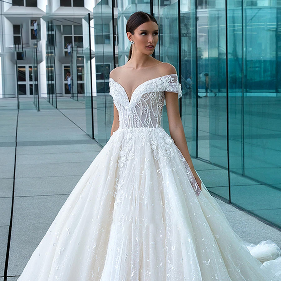 A-line wedding dress with a lace-up back, delicate lace appliques, and a glamorous, shimmering tulle design.