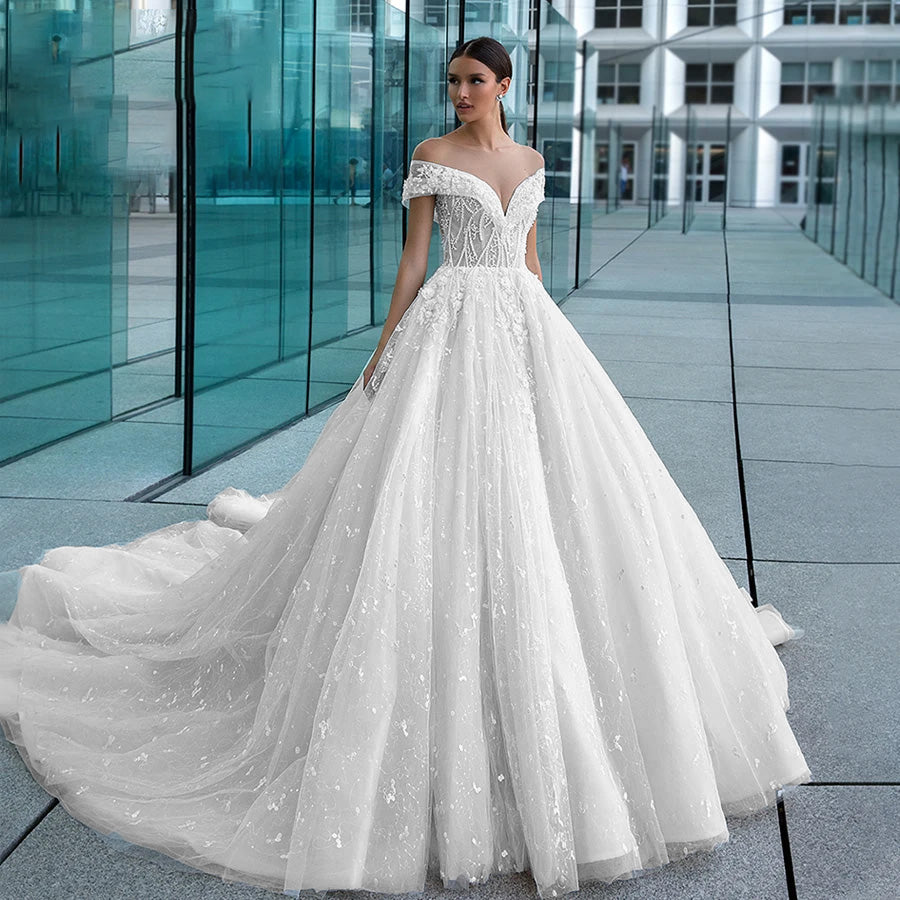 Elegant strapless A-line bridal dress with delicate beaded lace appliques and a voluminous, shimmering tulle skirt.