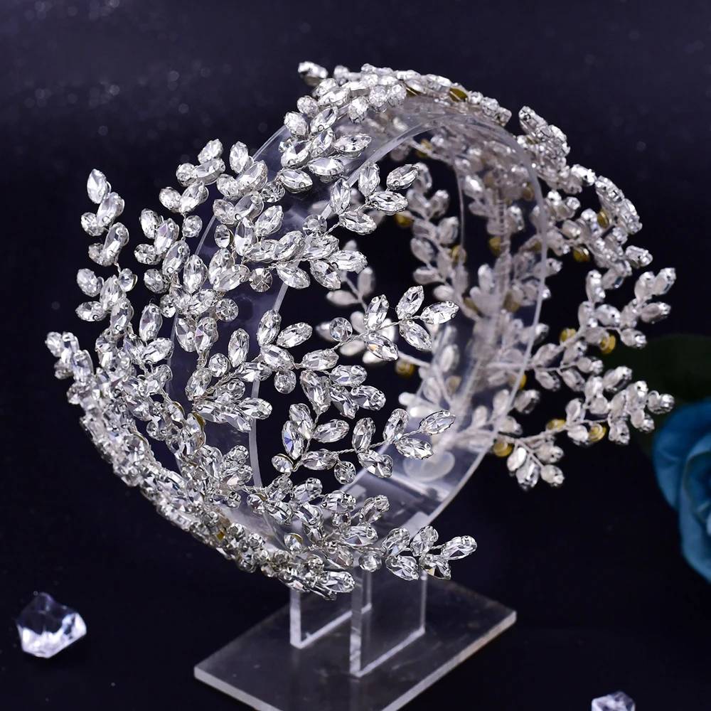 Luxury rhinestone bridal crown on display stand, detailed view of crystal leaf patterns