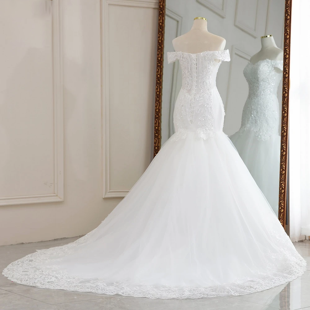 Rear view of the off-the-shoulder mermaid bridal gown on a mannequin, highlighting the detailed lace-up corset back and flowing train.