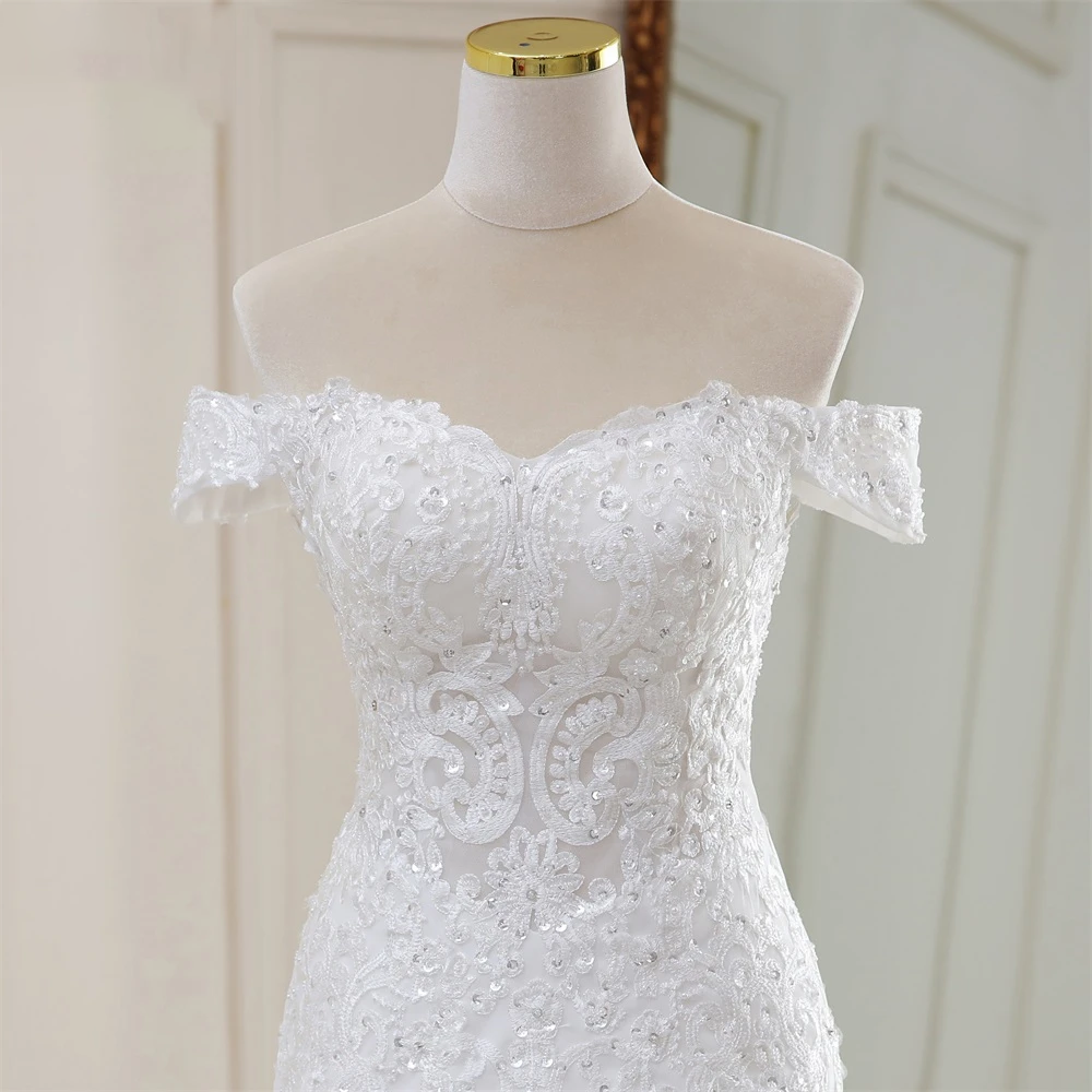 Detailed close-up of the sweetheart neckline and refined crystal embellishments on the off-the-shoulder lace bodice.
