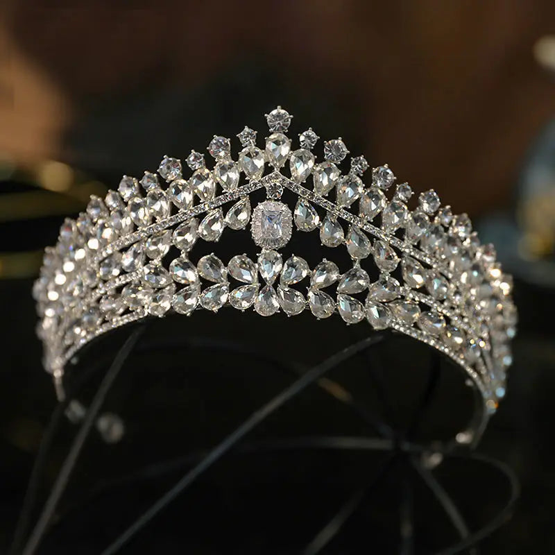 A wide silver bridal crown intricately packed with tiers of teardrop and brilliant-cut clear crystals.
