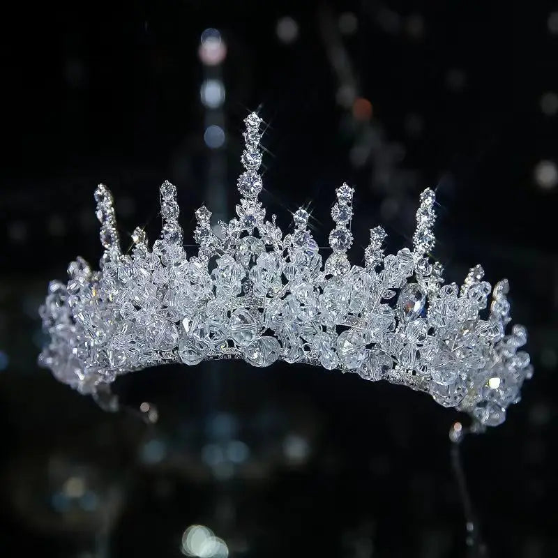 A luxury silver crystal bridal tiara crown featuring frosted crystal clusters and tall shimmering peaks.