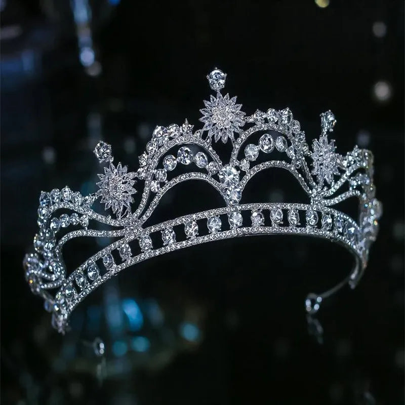 A statement silver bridal tiara crown featuring alternating starburst and circular crystal patterns along a structured band.