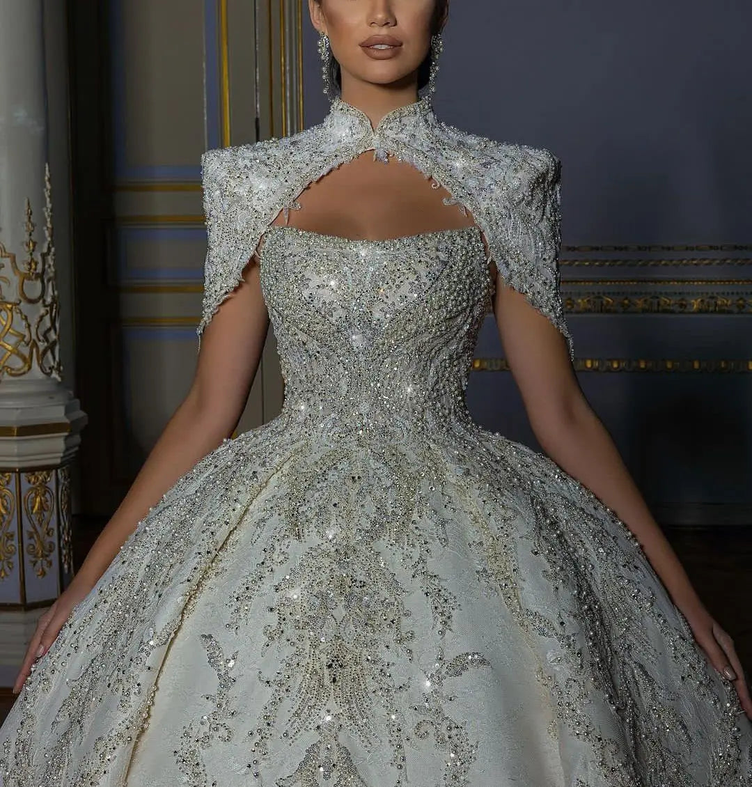 Luxury sleeveless princess wedding ball gown featuring a heavily crystal-beaded sweetheart bodice, paired with a matching high-neck keyhole bridal bolero jacket.