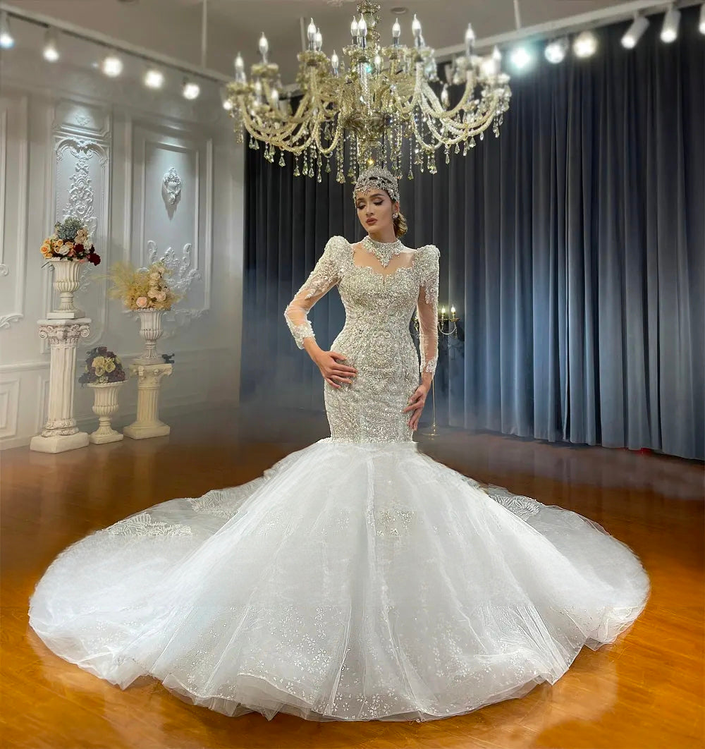 Elegant front view of a white beaded lace mermaid wedding gown featuring a dramatically flared tulle skirt and a long shimmering train.