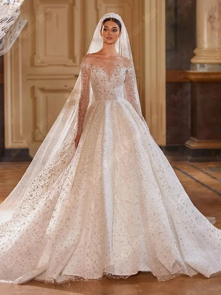 A portrait of a bride posing in a glamorous V-neck, long-sleeve sequined wedding dress, highlighting the intricate beading and voluminous skirt.