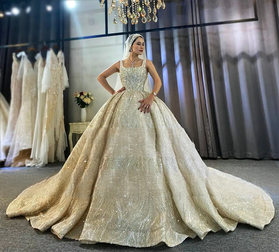 Full-length perspective of a stunning bride in a vintage sleeveless bridal ball gown, showcasing the elegant fit and the shimmering, voluminous skirt under a crystal chandelier in a bridal boutique.