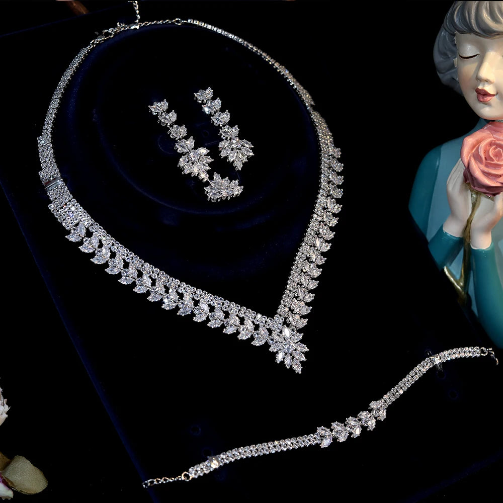 Side-angle display of a luxury crystal wedding necklace set inside a premium blue velvet gift box with an accompanying silver bracelet.