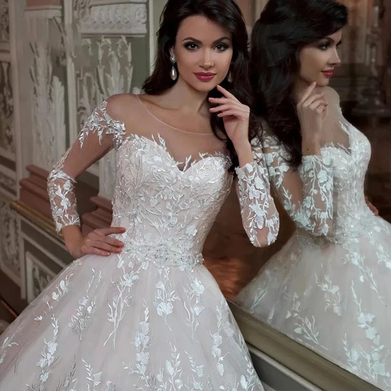 A bride posing in a luxury ball gown wedding dress, featuring delicate embroidery, an elegant O-neckline, and long sheer full sleeves.