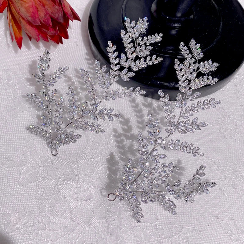 Alternate close-up look of the handmade marquise crystal wedding hairpins arranged on a white lace tablecloth backdrop to highlight stone clarity.