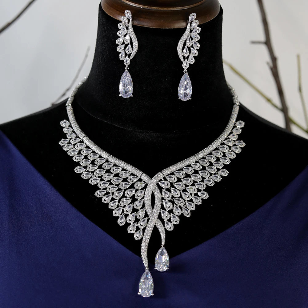 Front profile view of a stunning Dubai bridal CZ necklace and matching feather-motif earrings on a black display bust.
