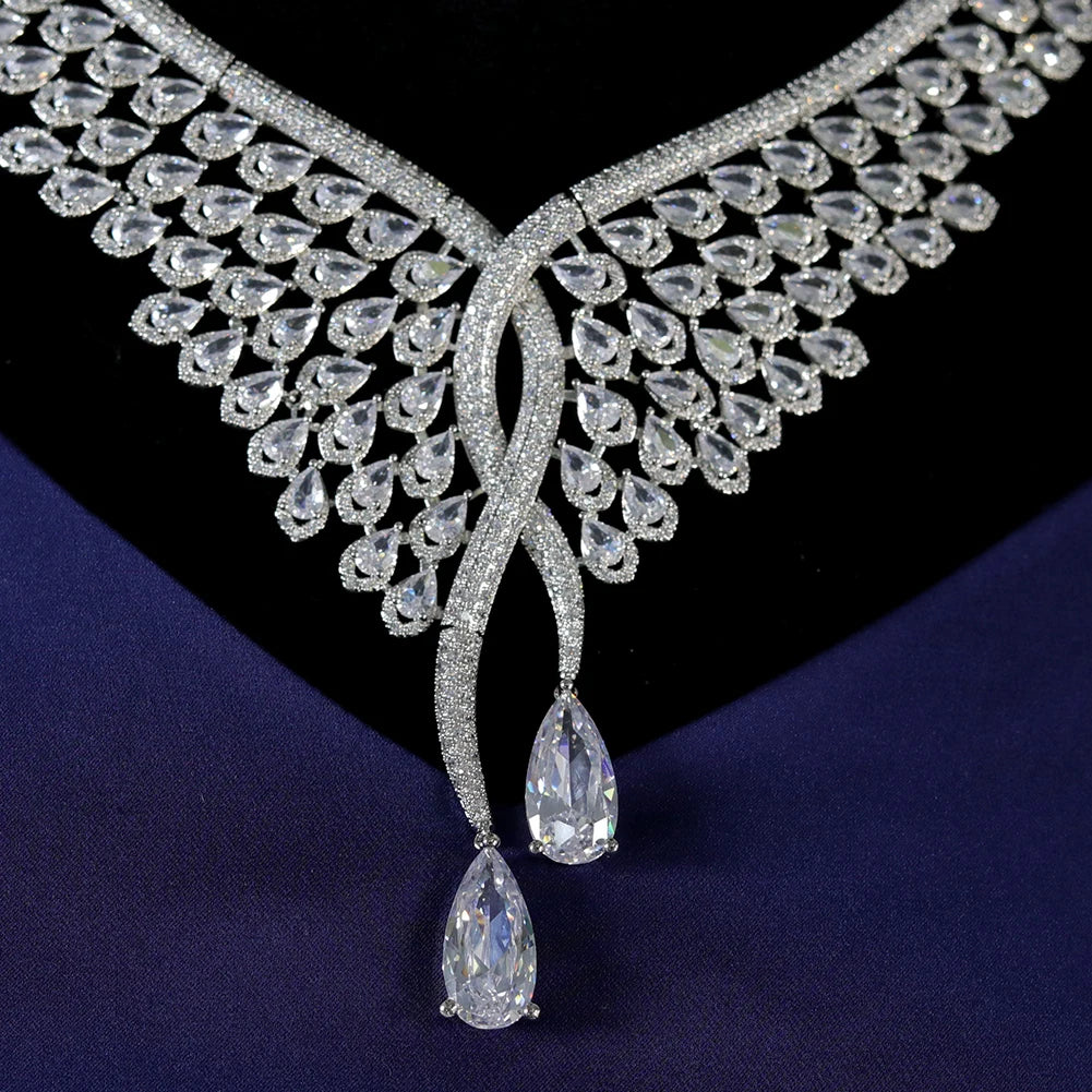 Detailed close-up macro shot of the central interlocking feather design and dangling teardrop gems on a wedding necklace.