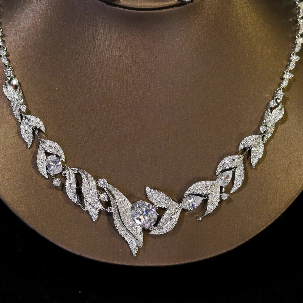 Elegant zircon bridal necklace featuring leaf motifs and center crystal stones on a display stand