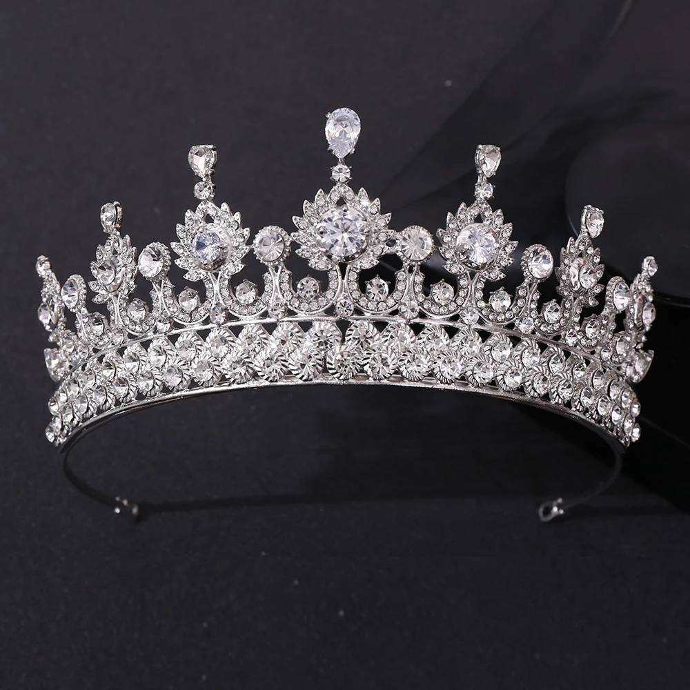 A classic princess wedding crown tiara heavily embellished with brilliant clear zircon crystals on a solid dark gray backdrop.