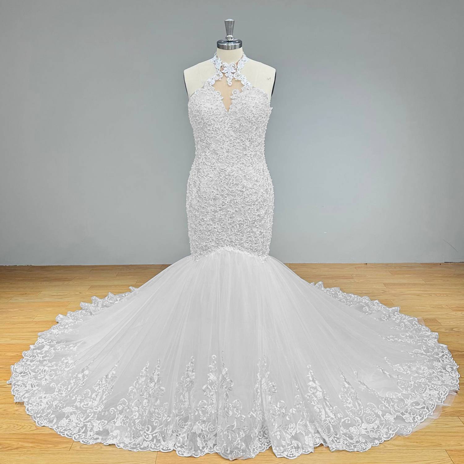 Front display of a vintage-inspired beaded halter neck trumpet wedding dress highlighting the form-fitting silhouette and scalloped lace details on a dress form.