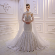 Front view of a model wearing a luxury mermaid wedding dress with a sweetheart neckline and a dramatic detachable high-neck lace cape.
