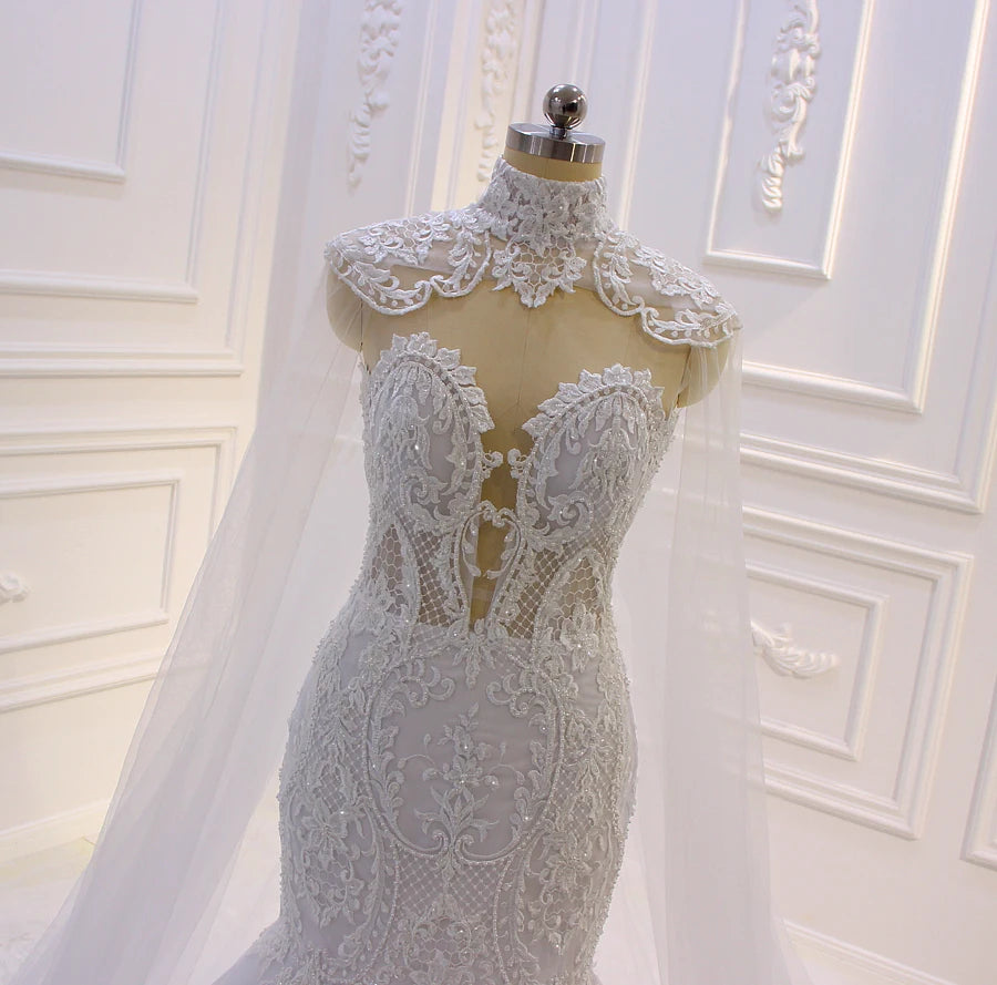 Close-up detail of the mermaid wedding dress bodice on a mannequin, focusing on the sheer plunge sweetheart neckline, intricate beaded lace, and high-neck cape collar.
