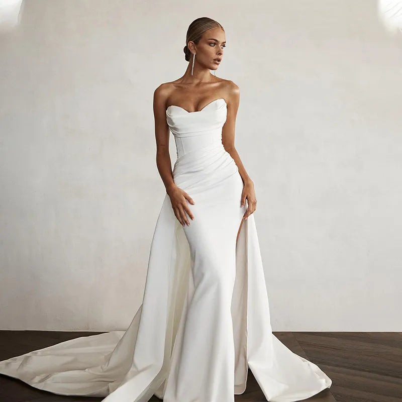 Elegant modern mermaid wedding dress with a dramatic front slit, sweetheart neckline, and a flowing sweep train.