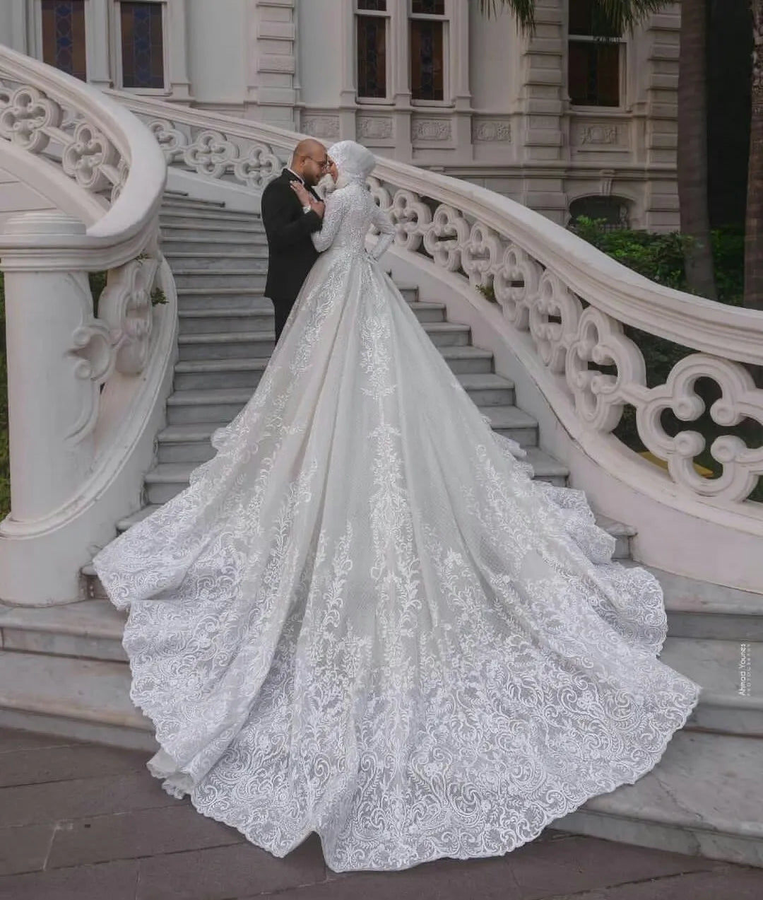 Close-up detail of the ornate lace embroidery on the bodice and long sleeves of a luxury Muslim bridal gown.