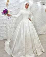 Elegant Muslim wedding dress featuring a high neckline, long sleeves, and an A-line skirt with intricate lace embroidery.