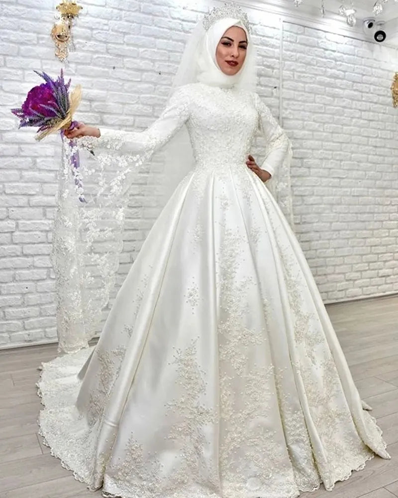 Elegant Muslim wedding dress featuring a high neckline, long sleeves, and an A-line skirt with intricate lace embroidery.