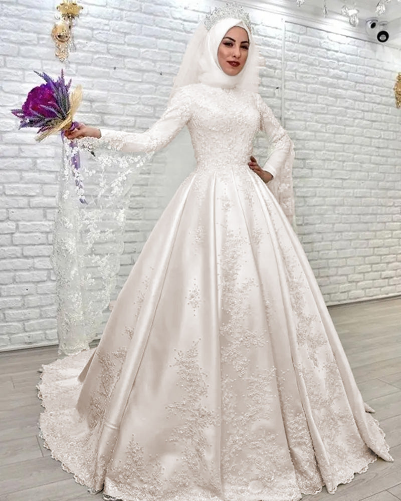 Close-up portrait of a bride wearing a modest, high-neck wedding dress with detailed lace and a elegant tiara.