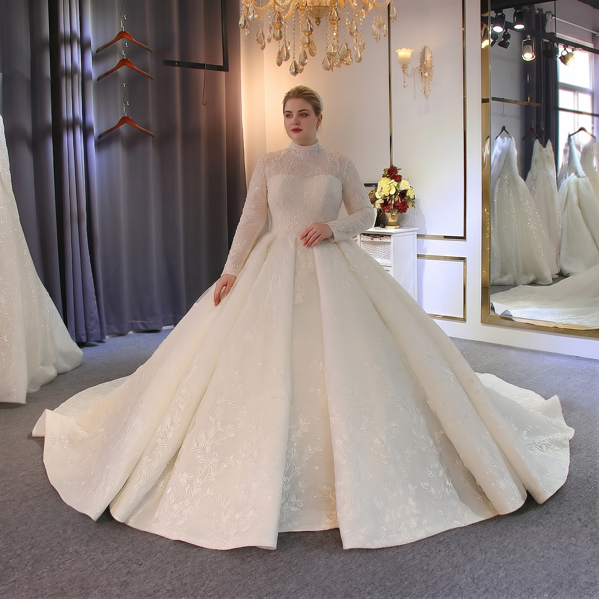 Elegant model posing in a full-lined Muslim bridal gown featuring a modest high collar, long sleeves, and a dramatic ball gown silhouette with shimmering lace detailing.