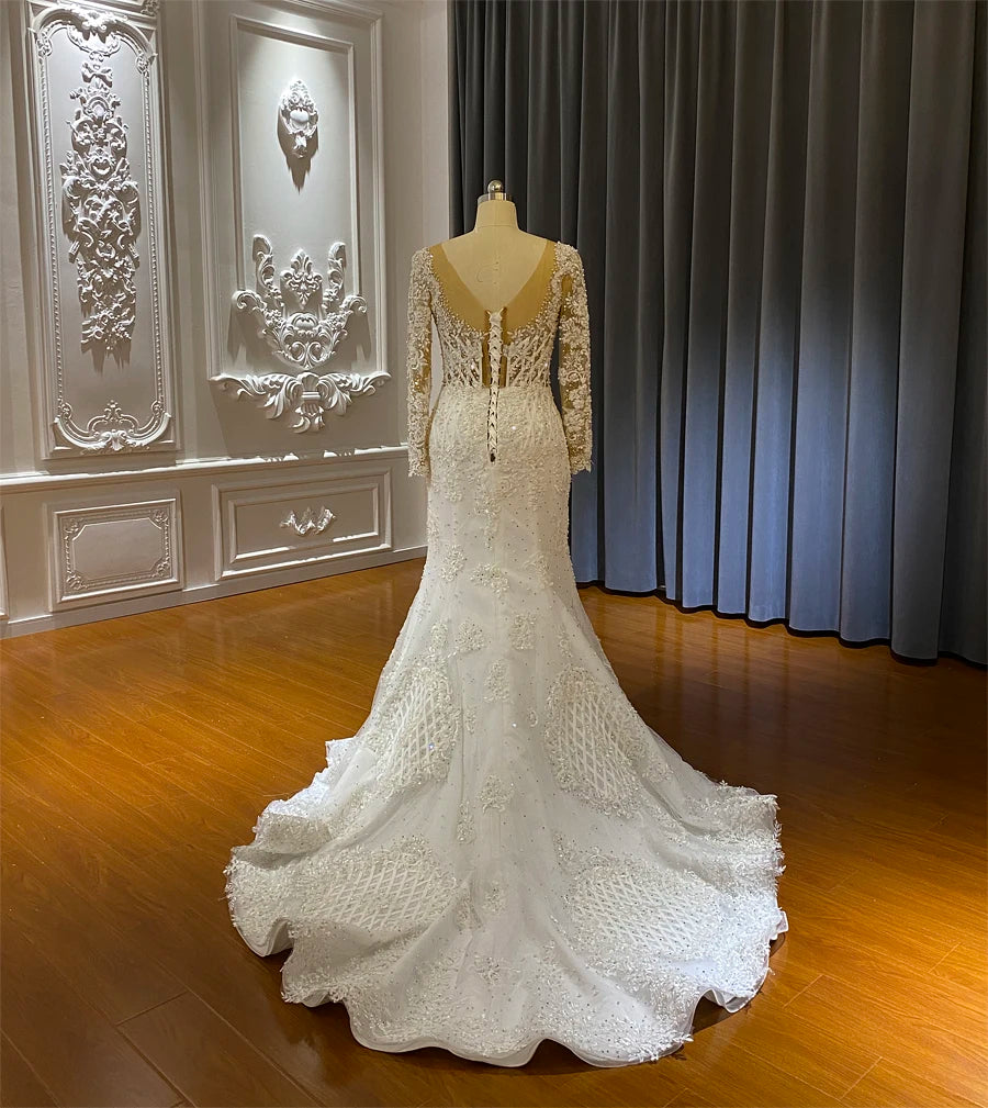 Back view of an elegant bridal gown showing a long lace-trimmed train and a sophisticated mermaid silhouette.