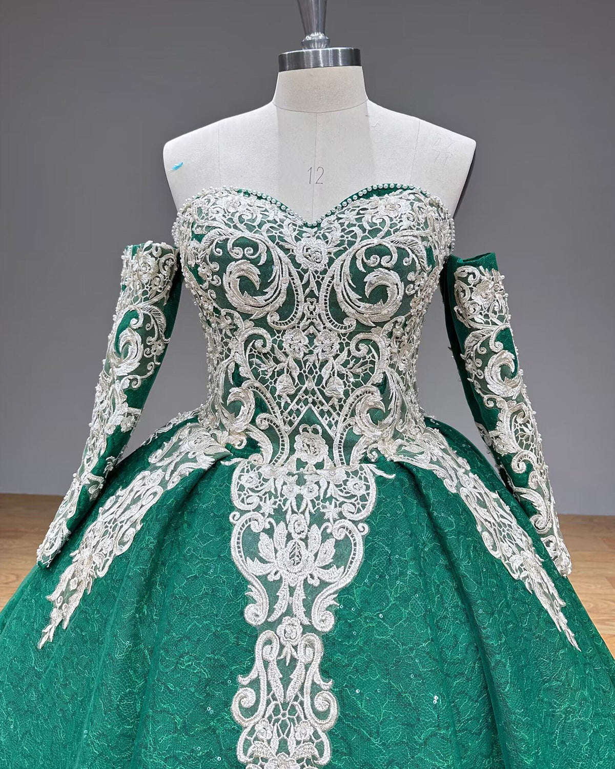 Detailed front close-up of the green ball gown bodice focusing on the baroque silver lace embroidery, delicate beadwork, and pearl-trimmed sweetheart neckline.
