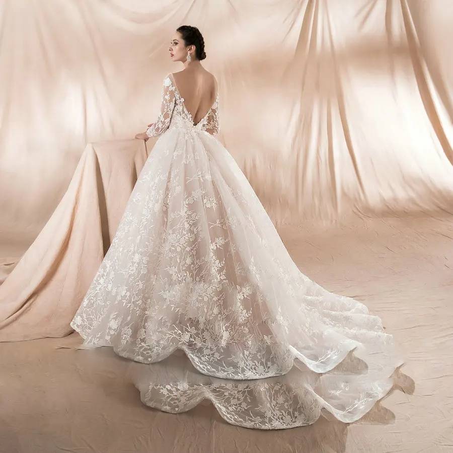 Back view of an elegant champagne wedding dress featuring a deep V-back and a long, sweeping train with scalloped lace edges.