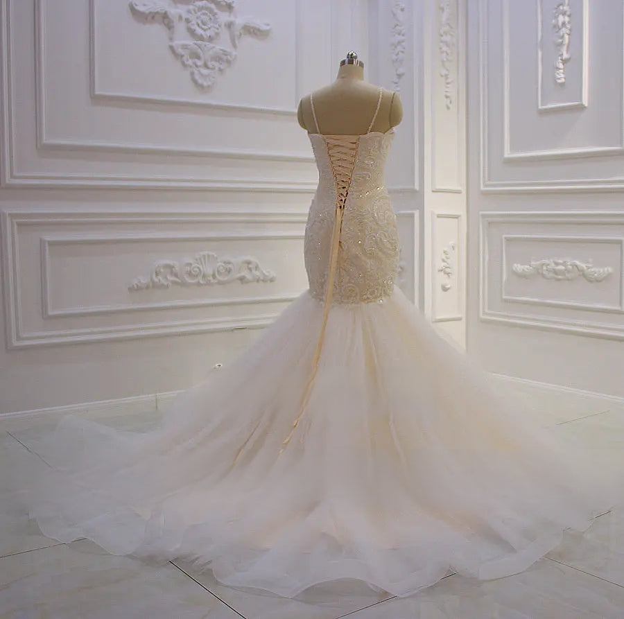 Back view of the mermaid wedding dress highlighting the elegant corset lace-up back and the sweeping tulle train.
