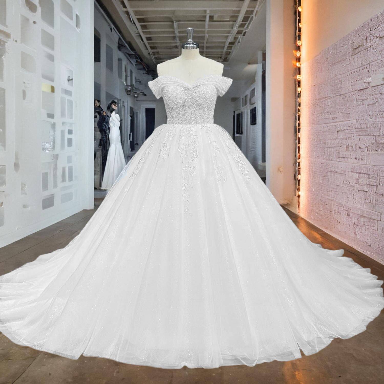 Front view of a luxury off shoulder ball gown wedding dress featuring intricate beaded pearl embroidery.