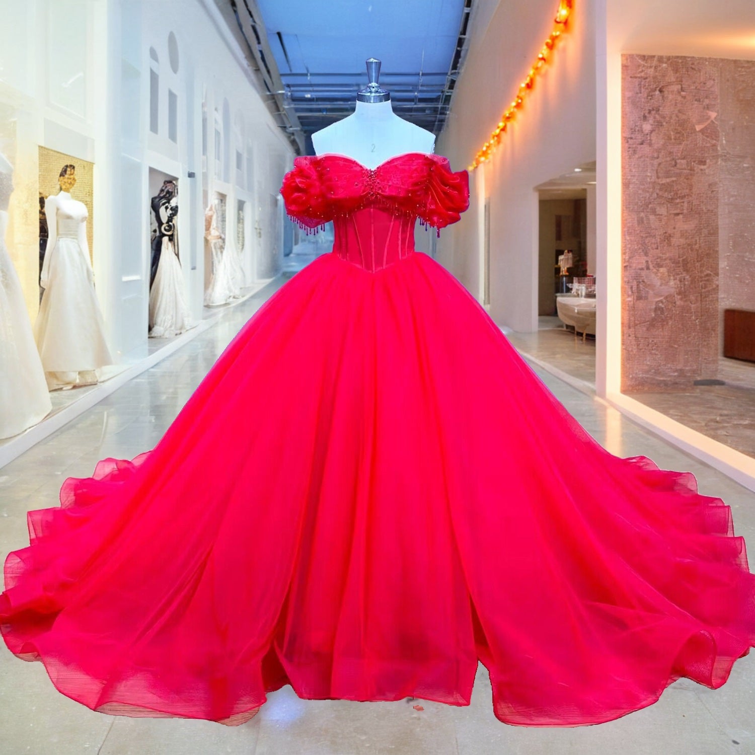 Front full-length display of the red off-the-shoulder quinceanera ball gown featuring a boned corset bodice and draped sleeves on a boutique showroom mannequin.