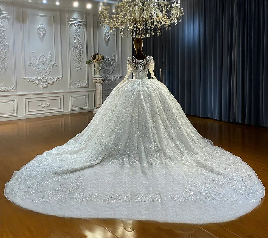 Breathtaking rear perspective of a majestic ball gown wedding dress highlighting a massive, sweeping cathedral-length train heavily embellished with sparkling sequins and lace appliques.